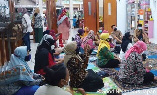 ヒジャブの上からマスクをつける女性たち