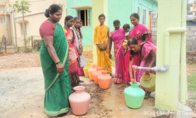 給水タンクから水をくむ女性たち