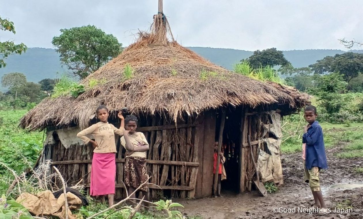 藁ぶき屋根の家と子ども達
